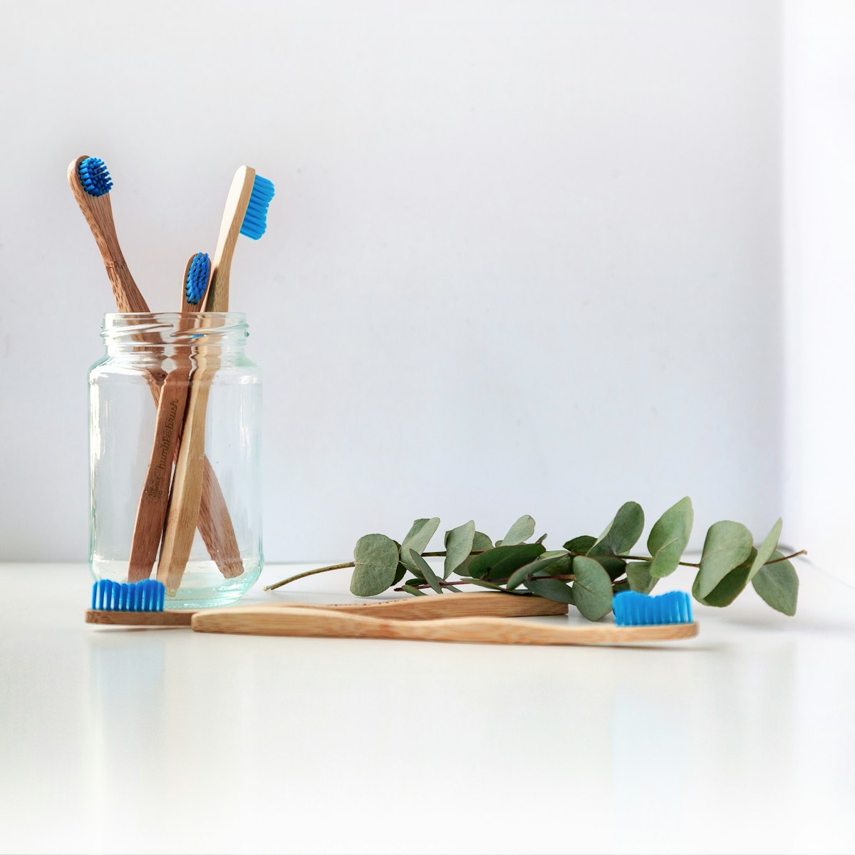 Malo Dental London oral care product flat-lay featuring the Bloomsbury sonic electric toothbrush and bamboo brushes on a white marble surface