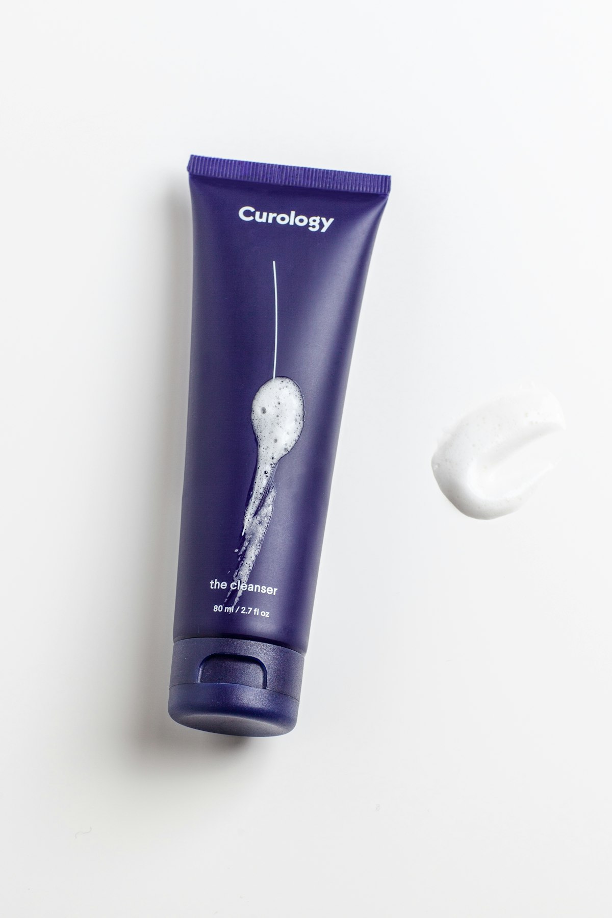 Three tubes of Malo Dental London Mineral Toothpaste in mint, charcoal, and fennel variants arranged on a white surface